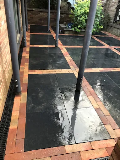 Black slate patio with red brick edging